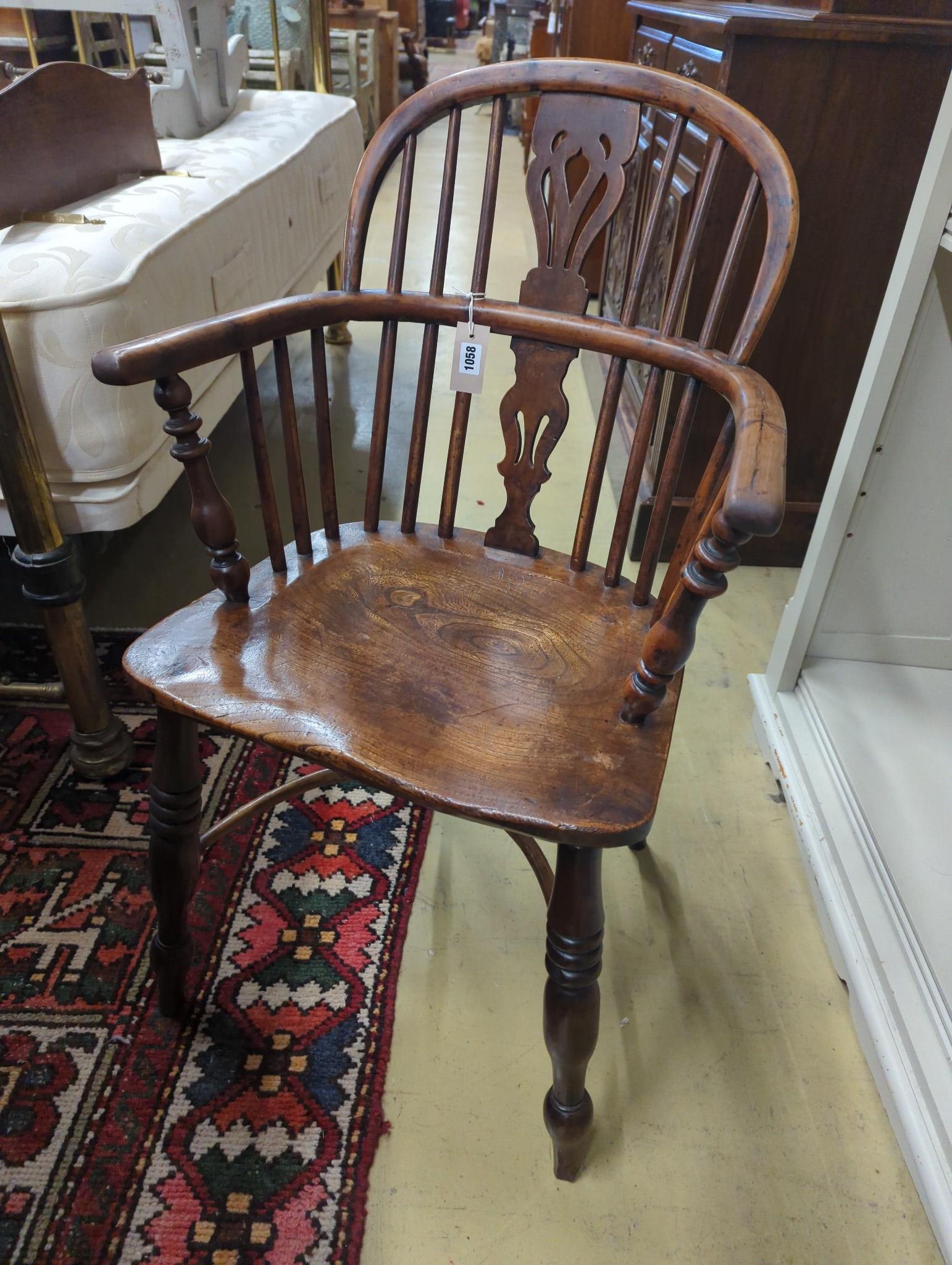 A near pair of mid 19th century Nottingham Area yew and elm Windsor elbow chairs with crinoline stretchers